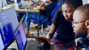 two programmers reviewing a laptop and monitor