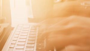 Close up image of hands typing on a laptop