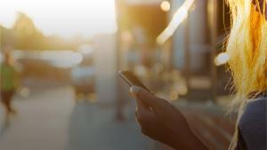 Person holding mobile phone outdoors