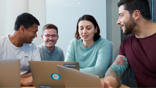 four teammates looking at a computer