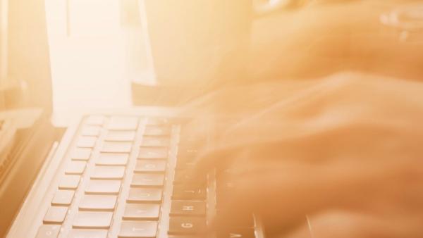 Close up image of hands typing on a laptop