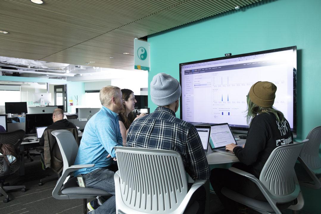 People sitting around a monitor at a table