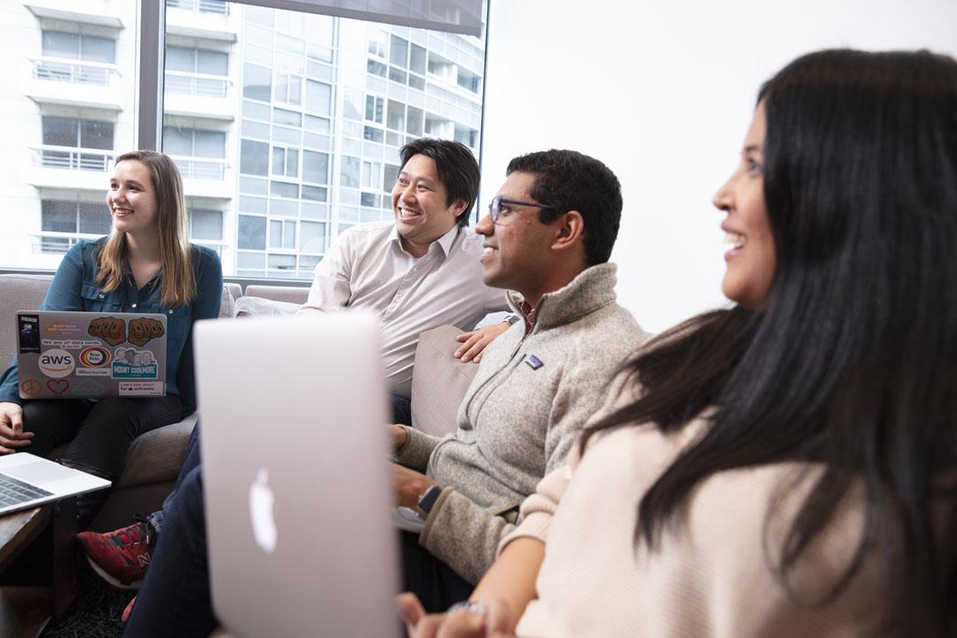 People in a meeting with laptops around a table