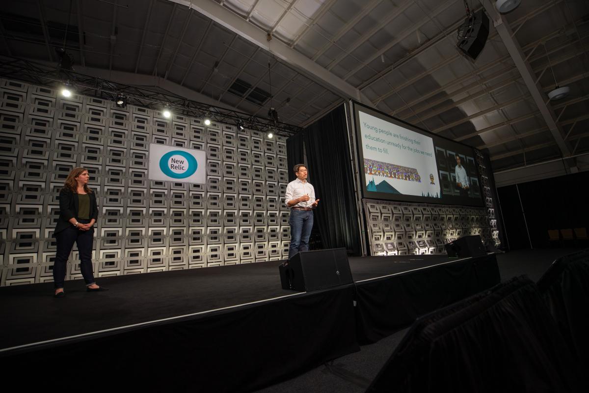 Two people on stage giving a talk
