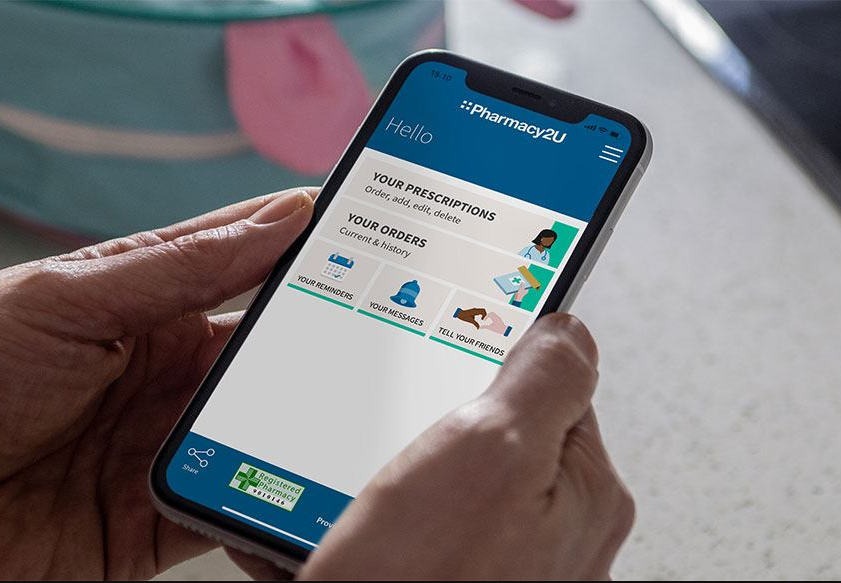 Person holds mobile with Pharmacy2U app open