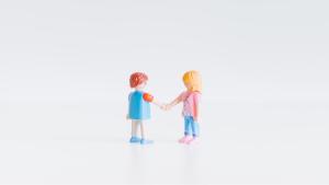 Two miniature doll-type figures shaking hands