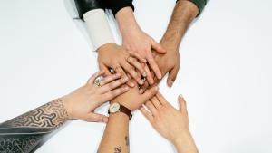 6 different hands on top of one another, unified