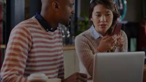 Two people working together on a laptop