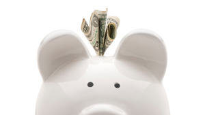 頭上からドル札が飛び出ているブタの貯金箱