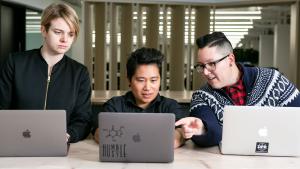Three developers investigating a laptop
