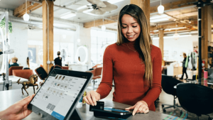 Femme utilisant sa carte à la caisse d'une boutique