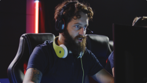 Developer working on a computer with headphones around his neck