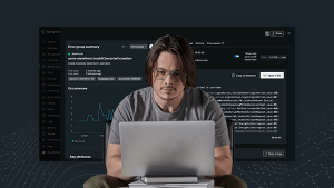 Individual using a laptop with New Relic dashboard as the background