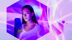 Photo d'une femme tenant et regardant un téléphone portable vue à travers un hexagone avec des vagues de lumière violettes