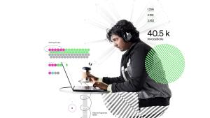 Engineer looking at computer while wearing headphones with a cup of coffee in hand