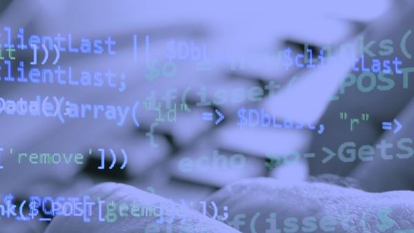 Close up of hands typing on a keyboard with code overlayed
