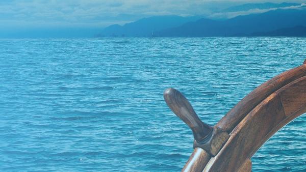 Ship wheel with ocean in background