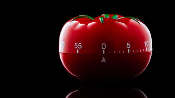 Tomato shaped kitchen timer on a black background