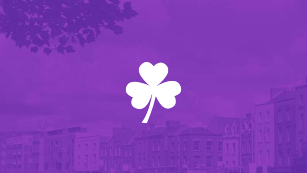 Símbolo de trébol sobre un fondo de color violeta y el horizonte de la ciudad de Dublín