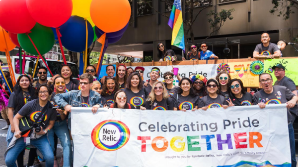 New Relic employees holding banner reading "Celebrate Pride Together"