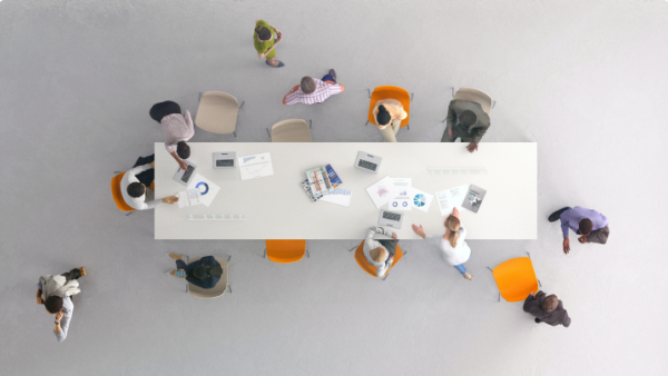 Overhead view of people gathered at a conference table to work
