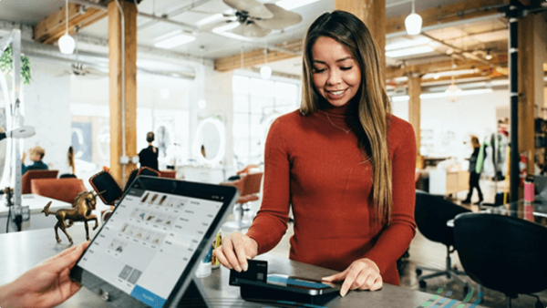 Woman swiping card at a retail checkout counter
