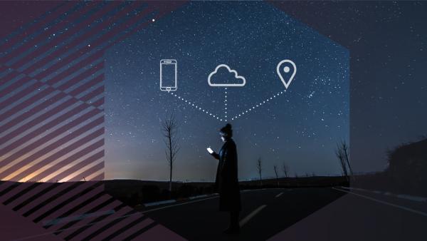 Person with phone standing in the road in a hexagon with icons of phone, cloud, and a pinpoint above their head