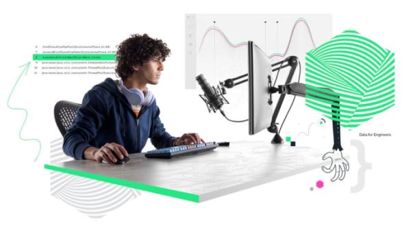 Person mit Computer am Schreibtisch, Grafiken im Hintergrund