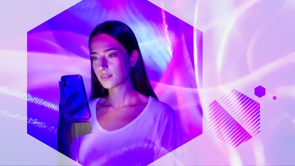 Imagen de una mujer mirando el teléfono móvil que tiene en la mano, visto en un hexágono con espirales de luz de color violeta
