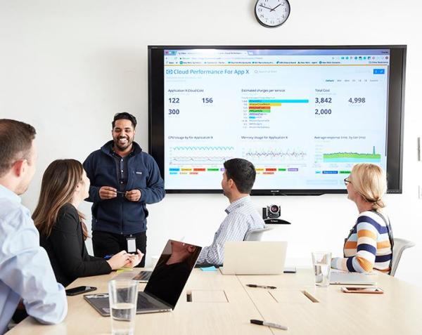 Person presenting to group at table 