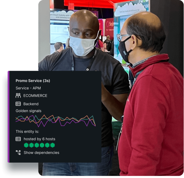 Two people conversing at reinvent with a New Relic AWS monitoring dashboard