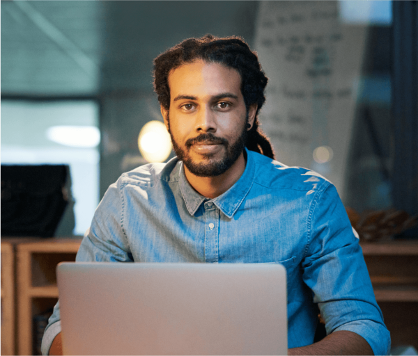 Developer seated at a desk working on his laptop