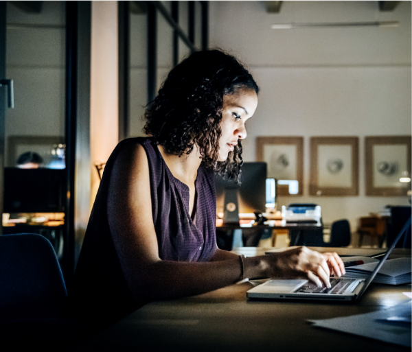 Mujer en una oficina trabajando en una laptop sobre un escritorio