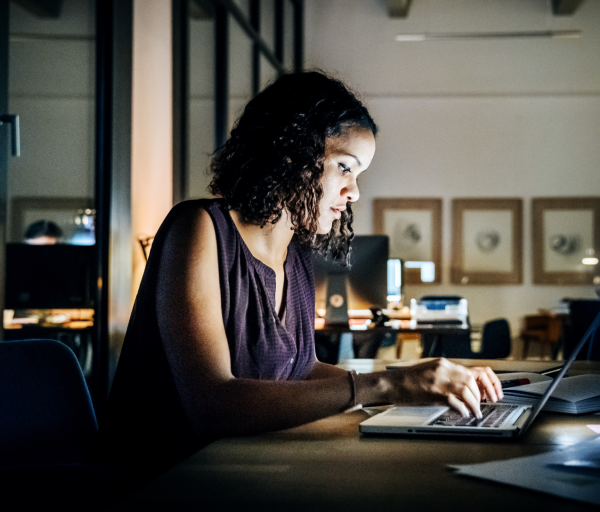 Person sat at a desk working on their laptop