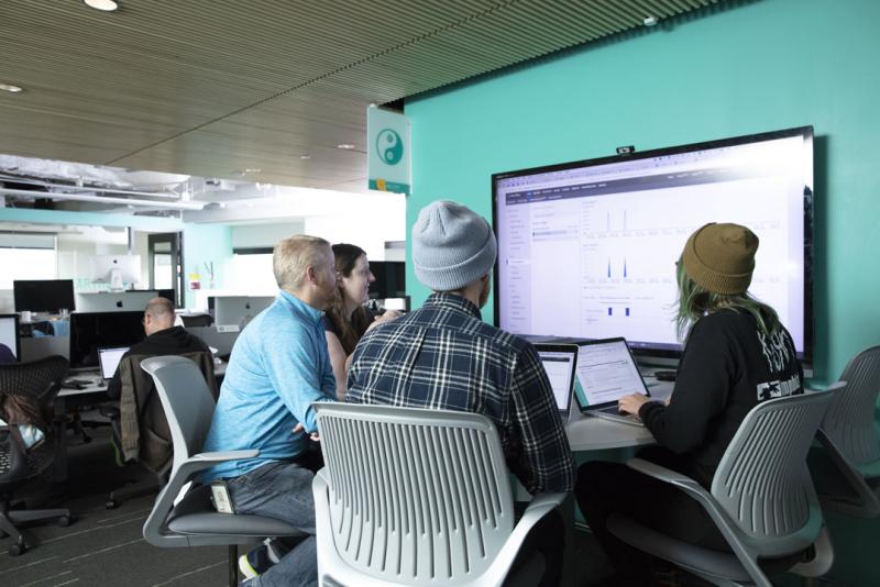 People sitting around a monitor at a table