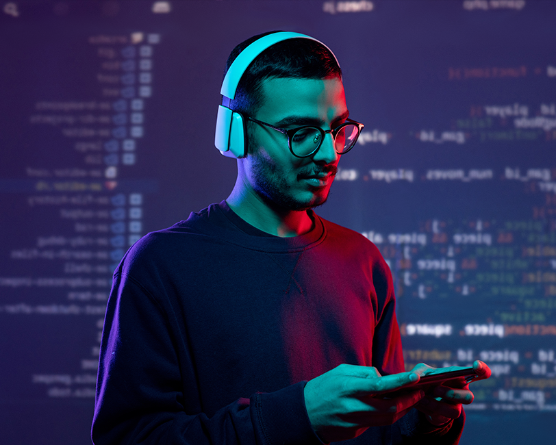 Person wearing headphones and using a mobile device with lines of code in the background