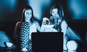 women watching movie on computer